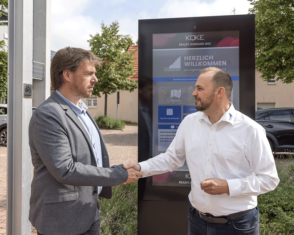 Dirk Koke übergibt das Digitale Gemeindeboard an Bürgermeister Patrick Koch